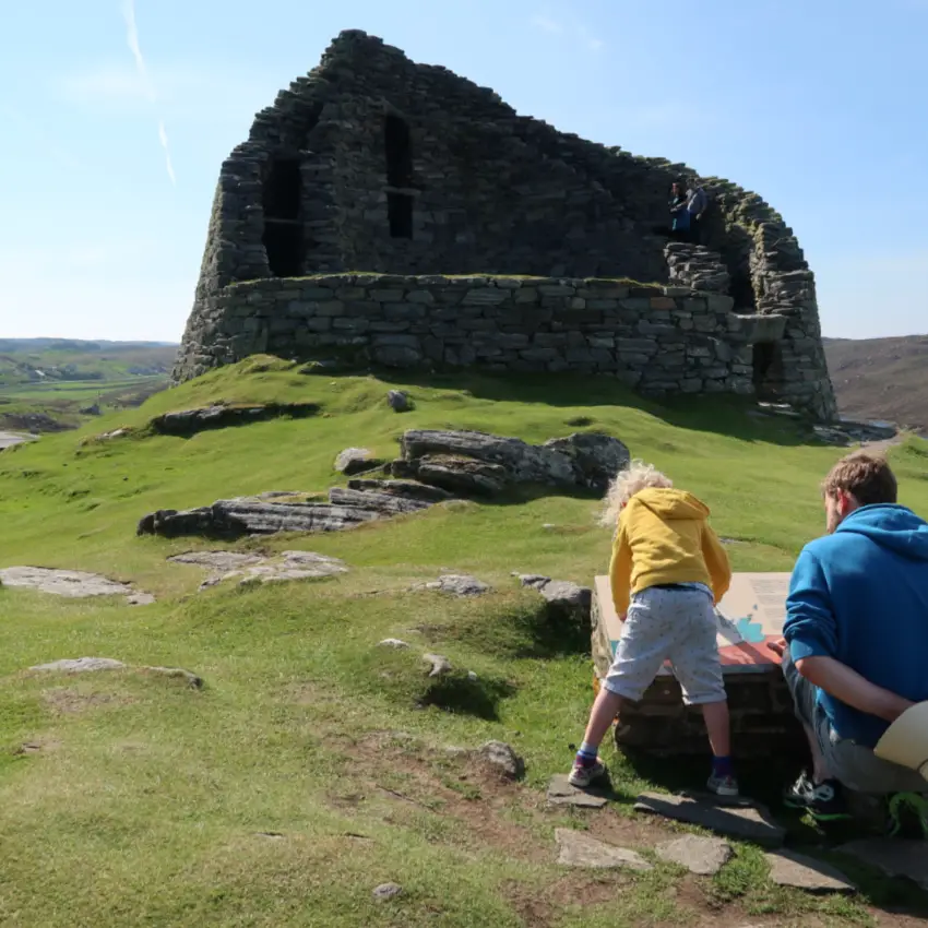 broch on Lewis with child and father looking at sign