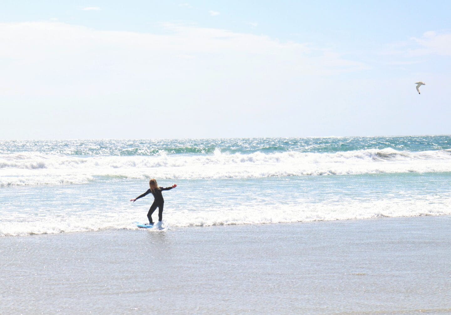 Child surfing close to beach